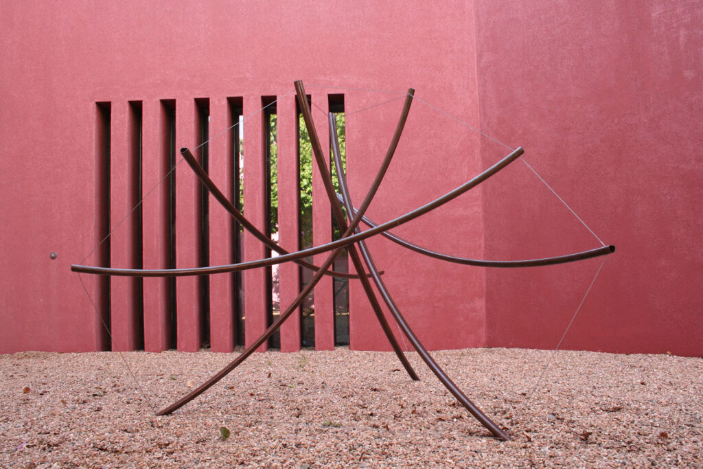 Outdoor tension sculpture.  Rolled steel tubing with Patinated finish.