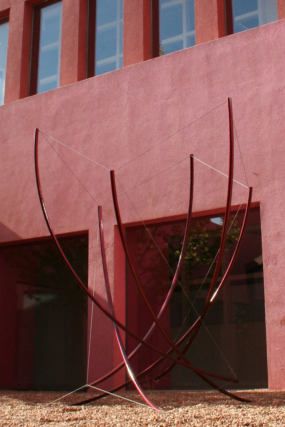 Outdoor tension sculpture.  Rolled steel tubing with Red Vein powder coat finish.